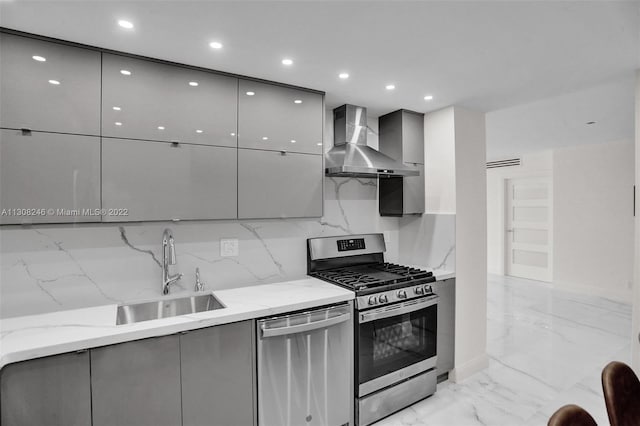 kitchen with light stone countertops, stainless steel dishwasher, wall chimney exhaust hood, and gas stove