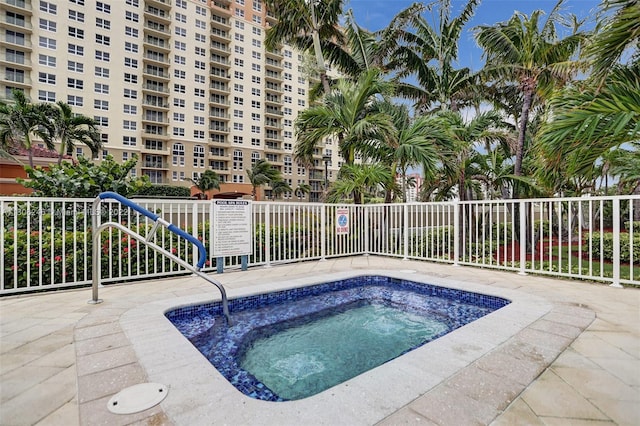 view of swimming pool with a hot tub