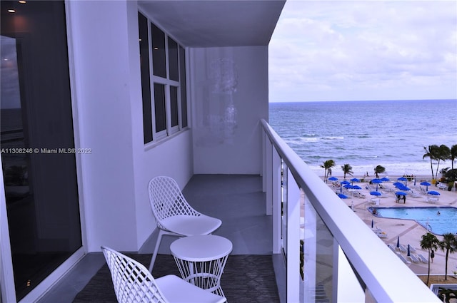 balcony with a water view and a beach view