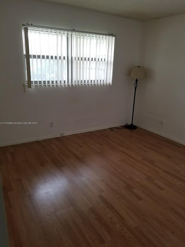 unfurnished room featuring dark wood-type flooring