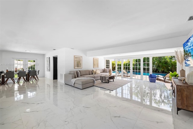 tiled living room with plenty of natural light and french doors