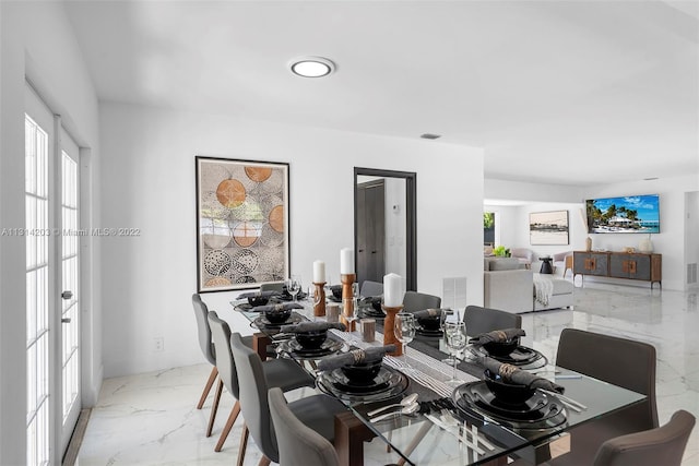 dining space with light tile flooring, plenty of natural light, and french doors