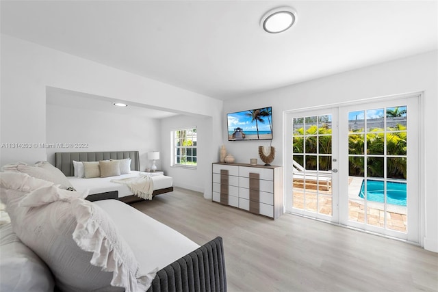 bedroom featuring access to outside, multiple windows, and light hardwood / wood-style floors