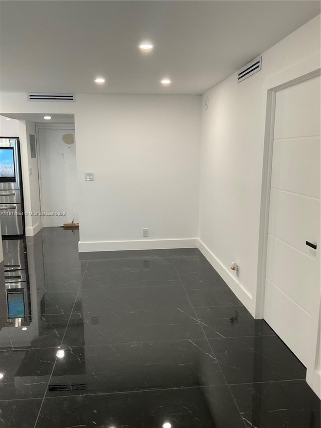 empty room featuring dark tile flooring