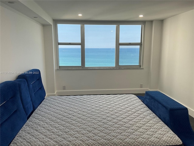 bedroom featuring carpet and a water view