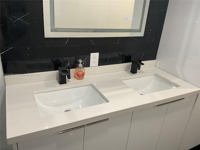 bathroom with tasteful backsplash, double sink, and oversized vanity