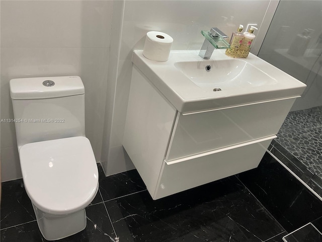 bathroom with toilet, tile floors, and vanity