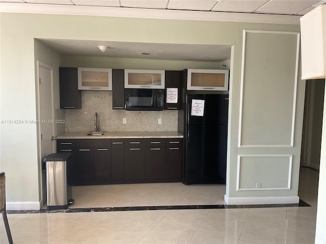 kitchen with backsplash, light tile floors, and black appliances