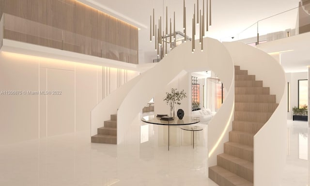 stairway with tile patterned flooring and a high ceiling