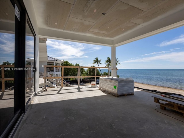 view of patio featuring a view of the beach and a water view