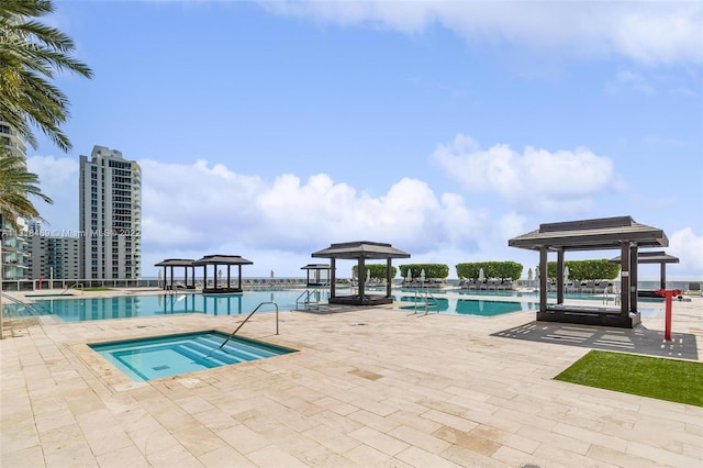 view of swimming pool featuring a community hot tub, a gazebo, and a patio area