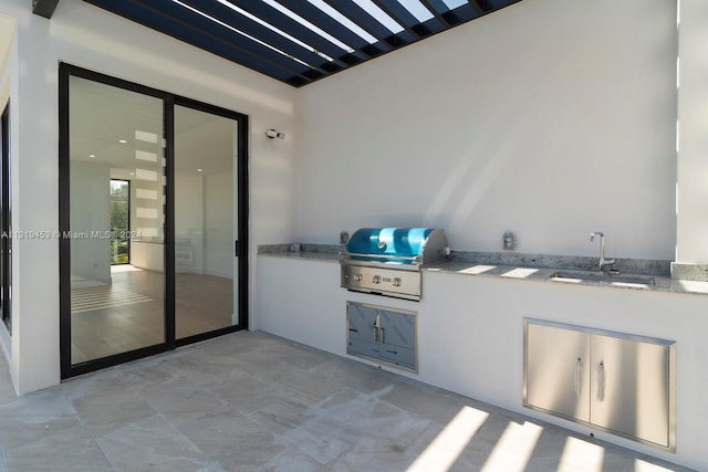 view of patio / terrace featuring exterior kitchen, a grill, and sink