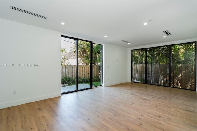 spare room featuring plenty of natural light and light hardwood / wood-style flooring