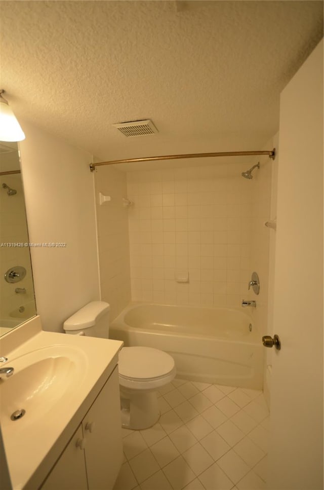 full bathroom featuring tile patterned floors, a textured ceiling, vanity, toilet, and tiled shower / bath