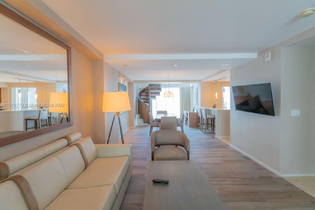 living room with an inviting chandelier and light hardwood / wood-style flooring