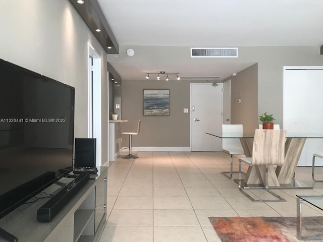 hall with track lighting and light tile floors