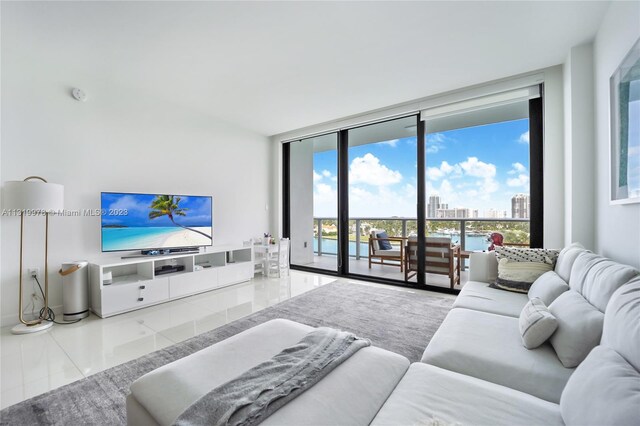 living room with a water view, tile floors, and expansive windows