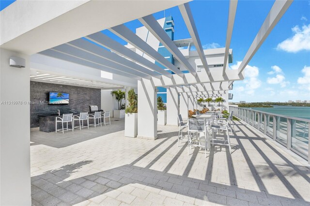 view of patio featuring exterior bar and a pergola