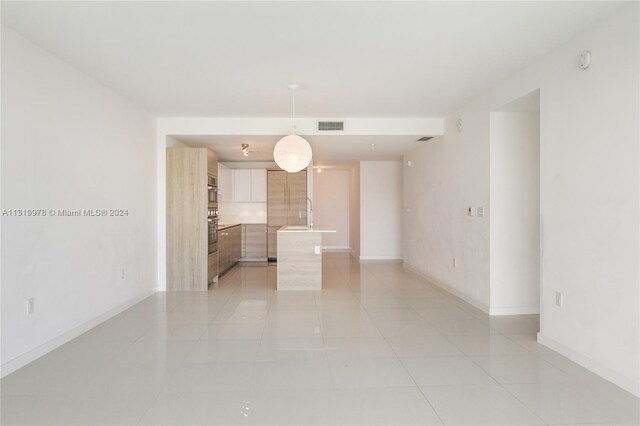 unfurnished room with sink and light tile floors