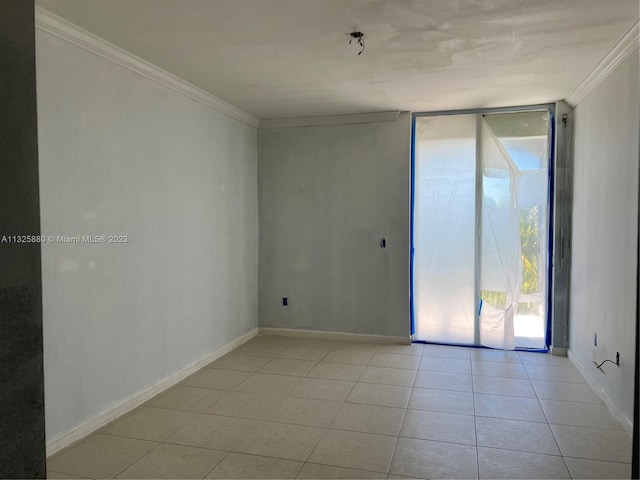 tiled empty room featuring floor to ceiling windows and crown molding