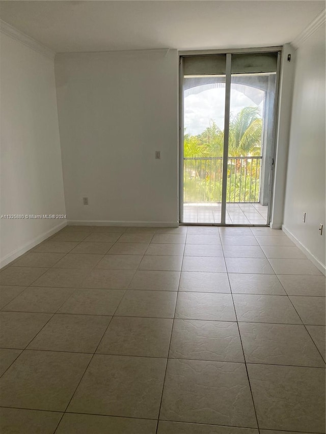 empty room with light tile floors and crown molding