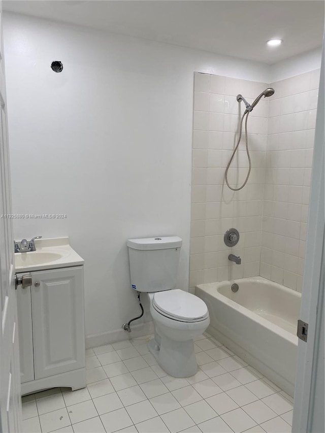 full bathroom featuring tiled shower / bath combo, tile floors, toilet, and vanity