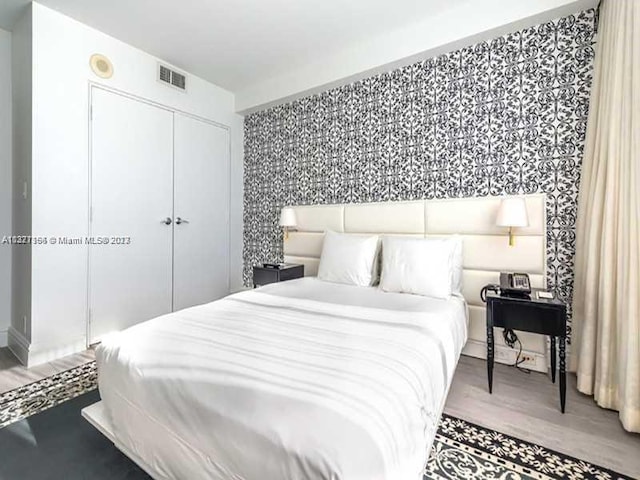 bedroom with wood-type flooring and a closet