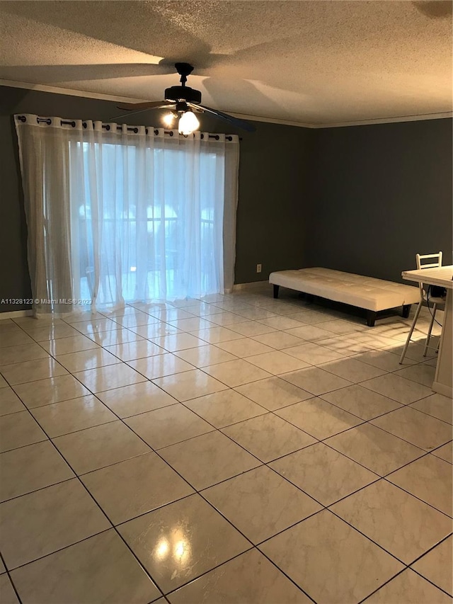 unfurnished bedroom with ceiling fan, light tile patterned floors, and a textured ceiling