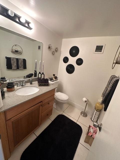 bathroom featuring tile patterned flooring, vanity, and toilet