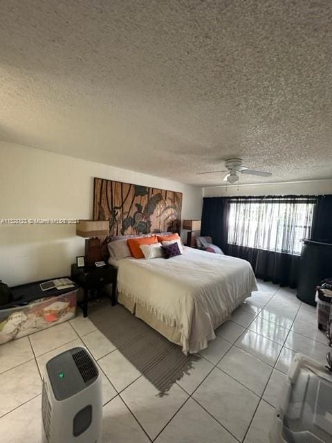 bedroom with light tile patterned floors, a textured ceiling, and ceiling fan