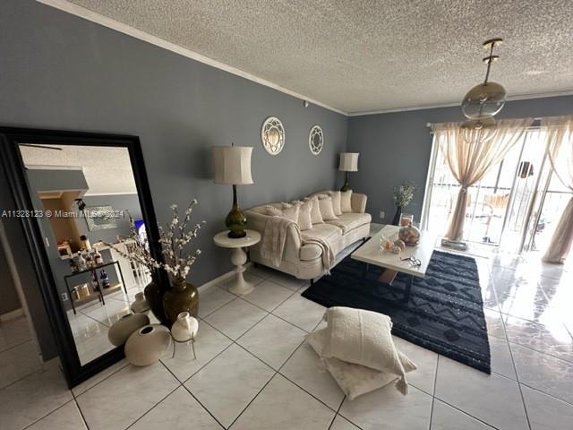 tiled living room featuring ornamental molding and a textured ceiling