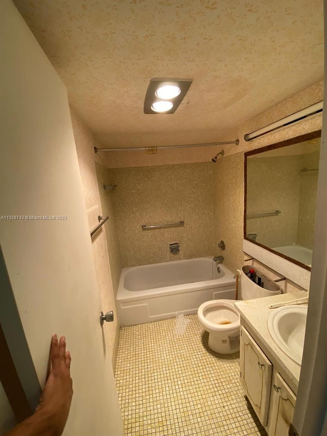 full bathroom with tiled shower / bath combo, vanity, tile floors, a textured ceiling, and toilet