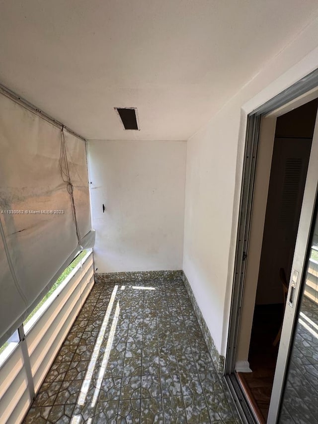 hallway with dark tile flooring