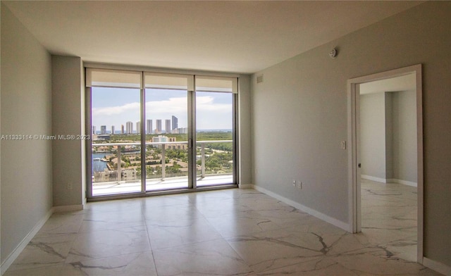 tiled empty room with a healthy amount of sunlight and expansive windows