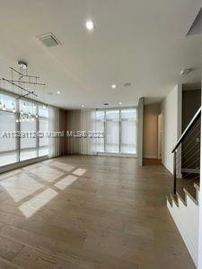 spare room with floor to ceiling windows and hardwood / wood-style floors