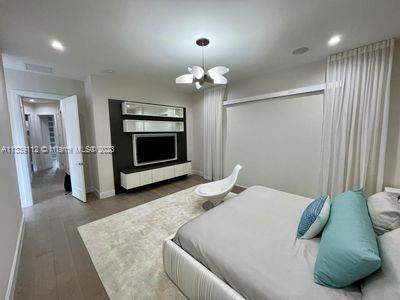 bedroom with a closet, a chandelier, and dark wood-type flooring