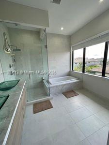 bathroom with separate shower and tub, vanity, and tile flooring