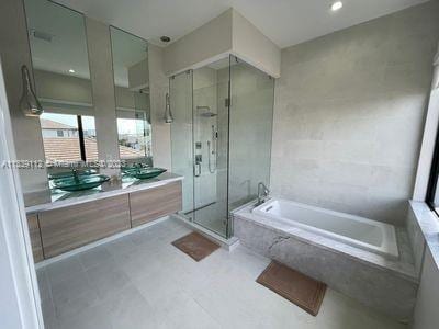 bathroom with vanity, tile floors, and plus walk in shower