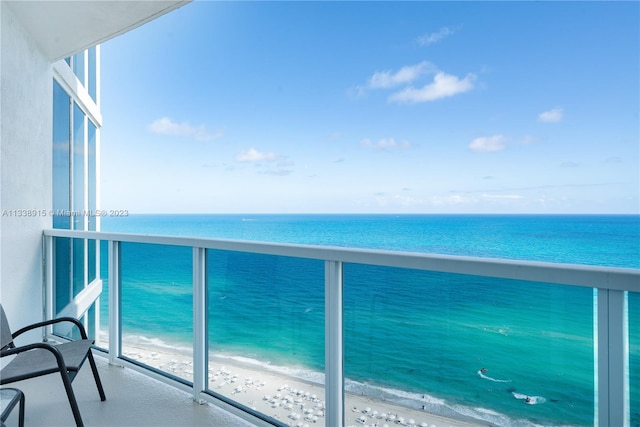 balcony featuring a beach view and a water view