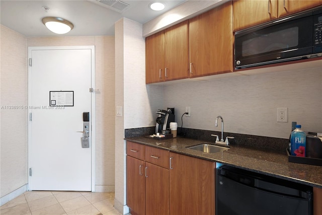 kitchen featuring dark stone counters, light tile floors, black appliances, and sink