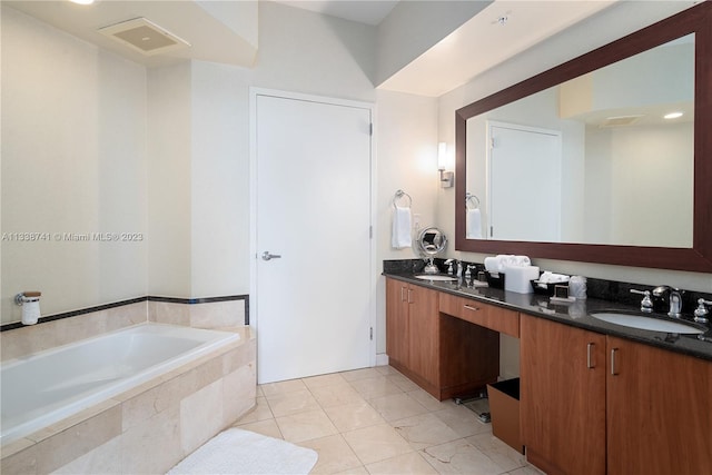 bathroom with tile flooring, dual sinks, vanity with extensive cabinet space, and tiled bath