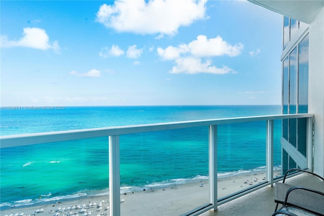 balcony featuring a water view and a beach view