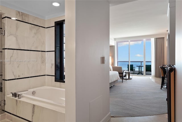 bathroom featuring tiled tub and a water view