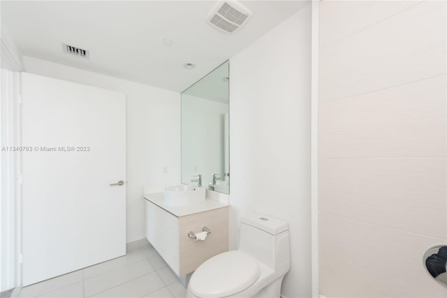 bathroom with tile flooring, vanity with extensive cabinet space, and toilet