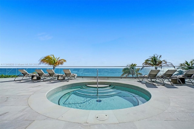 view of pool with a community hot tub and a water view