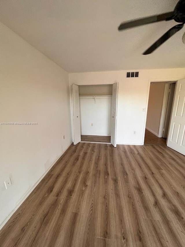 unfurnished bedroom featuring ceiling fan and dark wood-type flooring