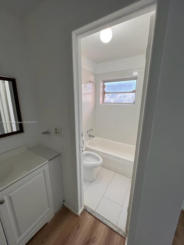 full bathroom featuring vanity with extensive cabinet space, toilet, tile floors, and tiled shower / bath