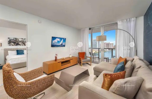 living room featuring a water view, expansive windows, and light hardwood / wood-style floors