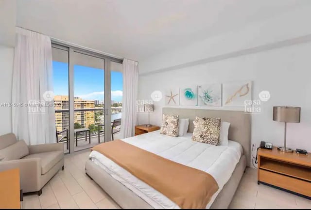 bedroom with access to exterior and a wall of windows