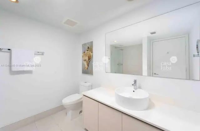 bathroom featuring vanity, tile floors, and toilet